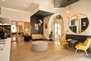 a living room with yellow chairs and a table at Hotel du Levant in Castellane