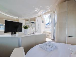 a white room with a tv and a bed at ANTHENEA Trebeurden in Trébeurden