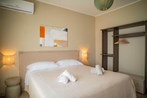a bedroom with a white bed with towels on it at Casa Mina in Taormina
