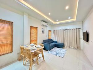 a living room with a table and a blue couch at Home 2 bedroom Rayong long stay Phala Beach in Ban Chang