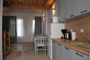 a kitchen with a white refrigerator and a table at Troyan Hill Apartments in Petra