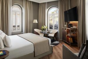a hotel room with a bed and a table and chairs at NH Collection Paris Ponthieu Champs-Élysées in Paris
