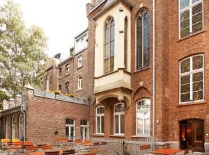 um edifício de tijolos com mesas e cadeiras em frente em HOPPER Hotel St. Josef em Colónia mais 80 fotografias