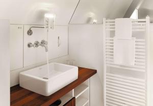um banheiro com pia branca e bancada de madeira em HOPPER Hotel St. Josef em Colónia