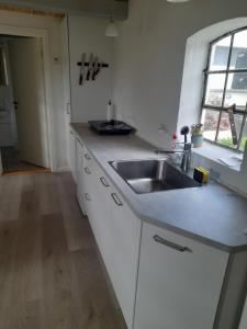 a white kitchen with a sink and a window at Hulen in Lund