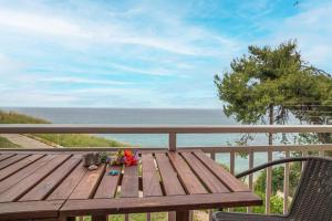 a wooden table on a balcony with a view of the ocean at Seagull House by RentalsPro - Nea Potidaia Hlkidiki in Nea Potidaea