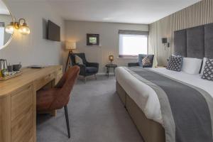 a hotel room with a large bed and a desk at The Crooklands, BW Signature Collection in Crooklands