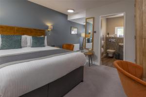 a hotel room with a large bed and a bathroom at The Crooklands, BW Signature Collection in Crooklands