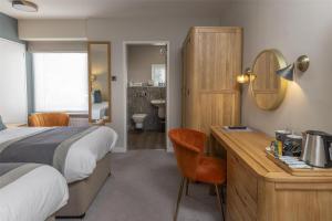 a hotel room with a bed and a desk with a mirror at The Crooklands, BW Signature Collection in Crooklands +122 photos