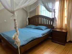 un dormitorio con una cama con dosel en house with a garden, en Kampala