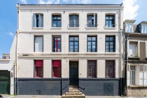 a white building with red windows and a door at Pop'Arras - Studio Hyper centre d'arras in Arras