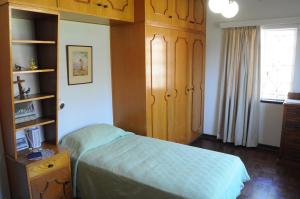 1 dormitorio con cama, armarios de madera y ventana en Luisa's Place, en Pretoria 1 foto más