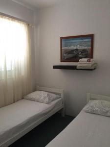 une chambre avec deux lits et un tableau au mur dans l'établissement Appartements Prisika Novi, à Novi Vinodolski