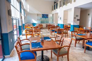 a dining room with wooden tables and chairs at Fiesta Inn Poza Rica in Poza Rica de Hidalgo