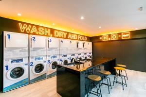a laundry room with washing machines and stools at Yume On Paulista in São Paulo