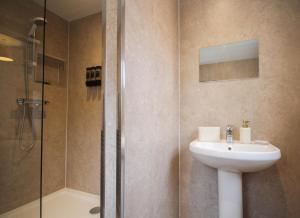 a bathroom with a sink and a shower at Spacious Home - 4 Bedrooms - Sleeps 9 - FREE Superfast 1GB Wi-Fi - 55" Smart TV - FREE Parking in Newcastle upon Tyne +26 photos