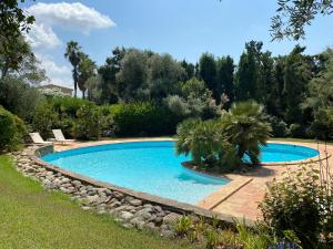 una piscina in un giardino con rocce e alberi di Bergerie a Grimaud