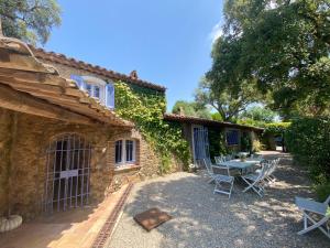 un patio con tavolo e sedie di fronte a un edificio di Bergerie a Grimaud