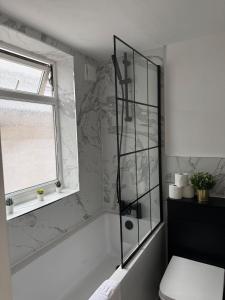 a bathroom with a shower with a toilet and a window at Spacious 4Bed - Next to Stadium in Sunderland
