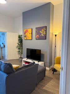 a living room with a couch and a television at Spacious 4Bed - Next to Stadium in Sunderland