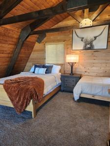 a bedroom with two beds in a log cabin at Rim Overlook Cabin Retreat in Duck Creek Village +26 photos