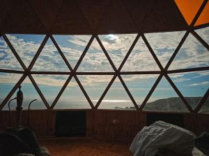 a large window in a room with a view of the ocean at DomoChango in La Serena