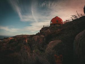 a red dome on top of a rocky hill at DomoChango in La Serena +1 photo