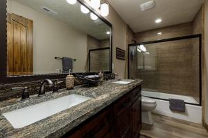 a bathroom with a sink and a toilet and a mirror at Mossberg Luxury Retreat in Duck Creek Village +57 photos
