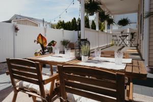un tavolo in legno sul portico posteriore di una casa di Back at Belmar a Belmar Altre 18 foto