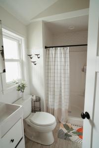 un bagno bianco con wc e doccia di Back at Belmar a Belmar