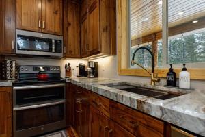 a kitchen with a sink and a stove and a microwave at Aspen Glow Brand New Hot Tub in Duck Creek Village +44 photos