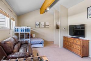 ein Wohnzimmer mit Ledercouch und Fernseher in der Unterkunft Aspen Summit Retreat in Brian Head