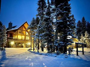 a house with snow covered trees in front of it at Good Karma Cabin - Luxury Mountain Retreat in Duck Creek Village