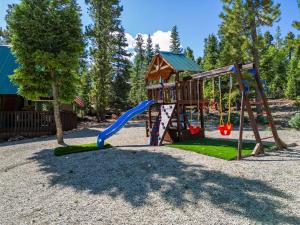 ein Spielplatz mit Rutsche und Schaukel in der Unterkunft Green Pines Cottage in Duck Creek Village