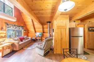 ein Wohnzimmer mit Holzwänden und einem Kühlschrank in der Unterkunft Green Pines Cottage in Duck Creek Village