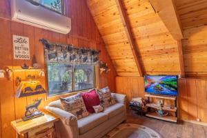 ein Wohnzimmer mit Sofa und Fernseher in der Unterkunft Green Pines Cottage in Duck Creek Village + 10 Fotos