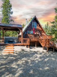eine Blockhütte mit einer großen Terrasse und einem Pavillon in der Unterkunft Green Pines Cottage in Duck Creek Village
