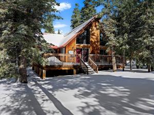 a log cabin in the snow with trees at Cozy Bear Cabin in Duck Creek in Duck Creek Village