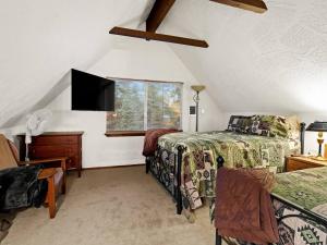 a bedroom with two beds and a tv and a window at Cozy Bear Cabin in Duck Creek in Duck Creek Village