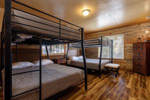 due letti a castello in una stanza con pareti in legno di Pine View Cabin Retreat, Hot Tub, Walk Out Patio a Duck Creek Village