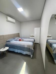 a bedroom with two beds and a table in it at VivaVida Imperial 103 in Sinop +13 photos