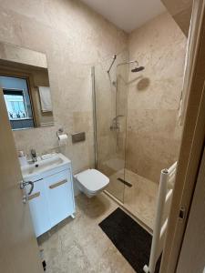 a bathroom with a shower and a toilet and a sink at La Dolce Riva Apartments - Navodari Mamaia-Sat in Mamaia Nord +12 photos