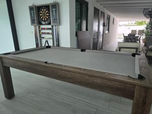 a pool table in a living room with a clock at 3 Bed 2 Bath Family House w Private Pool Dorado del Mar in Dorado
