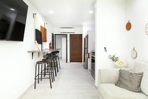 多拉多3 Bed 2 Bath Family House w Private Pool Dorado del Mar的厨房以及带酒吧和凳子的客厅。