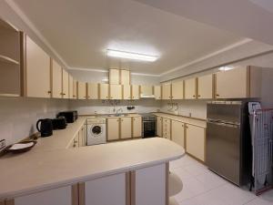 cocina con armarios de madera y encimera blanca en 3 Bedroom Apt 15 Min Walk to Fátima Sanctuary, en Fátima