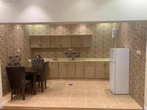 a kitchen with a table and a white refrigerator at القصر الضيافة 2 in Khamis Mushayt +10 photos
