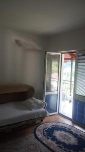ein Schlafzimmer mit einem Bett und einer Glasschiebetür in der Unterkunft Apartmani Krsman 2 in Herceg-Novi