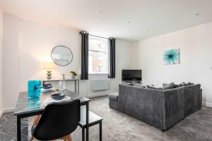 ハルにあるHull City Centre Sleeps 4 Free Parkingのテーブルとソファのあるリビングルーム