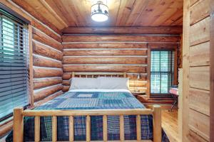 Park FallsにあるPier and Lake-View Patio Wisconsin Northwoods Cabinの丸太小屋のベッドのある寝室