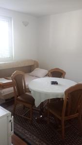 Zimmer mit einem Tisch, Stühlen und einem Sofa in der Unterkunft Apartmani Krsman 2 in Herceg-Novi